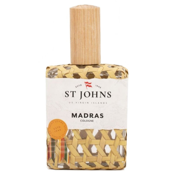A bottle of St. Johns Madras Cologne 4 Oz. Spray from the US Virgin Islands, wrapped in a woven material with a wooden cap. The scent features hints of fresh mandarins and black pepper, creating a vibrant and invigorating aroma.
