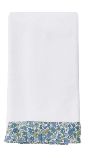 A white cloth napkin trimmed with blue, green, and white Liberty London fabric echoes the elegance of Weezie Towels' Weezie x Liberty London Powder Bath Towel—perfect for pairing with plush, absorbent terry linens.