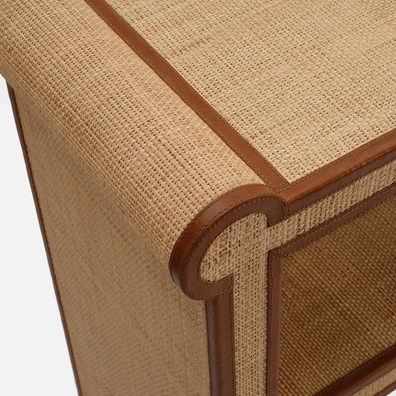 Close-up of the Large Matthew Console by Made Goods, featuring woven rattan with full-grain leather trim and unique contours, set against a plain background.