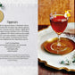 A red cocktail garnished with an orange twist sits on a gold tray next to a Teeling whiskey bottle and a Simon & Schuster Whiskey Cocktails recipe book open to a cocktail recipe.
