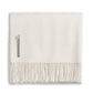 The Alicia Adams Alpaca Classic Throw Collection features a cream-colored baby alpaca blanket, fair-trade made in Peru, neatly folded with fringed edges and a small fabric label.