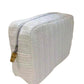 The Big Glam Bag in Straw White by TRVL Design features a rectangular shape, textured chevron pattern, tan pull tab, and zipper closure—an eco-friendly choice for style and sustainability.