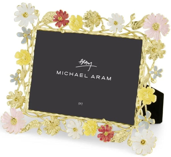 Decorative Michael Aram Wildflowers Frame, 5x7 from the Wildflower Collection, featuring botanical illustrations in gold and pastel colors on hand-enameled metal, with a prominent designer signature on a black background.