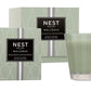 A Nest Wild Mint & Eucalyptus Candle from the Wild Mint & Eucalyptus Candle Collection is displayed beside its matching box, emphasizing the refreshing scents of wild mint and eucalyptus.