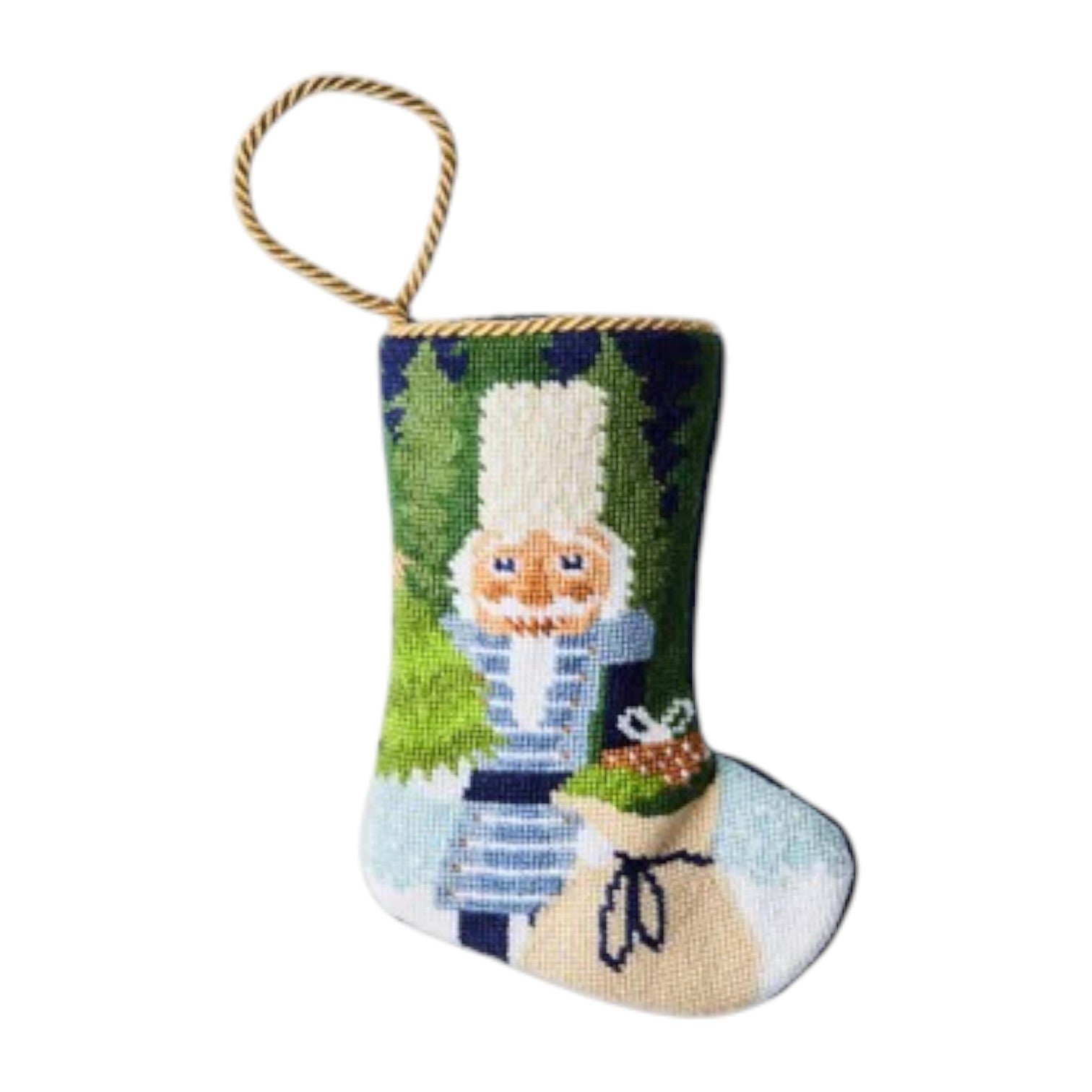The Bauble Stockings Winter Solstice Nutcracker Needle Point Stocking features a hand-stitched nutcracker and toy sack design with a gold hanging loop.