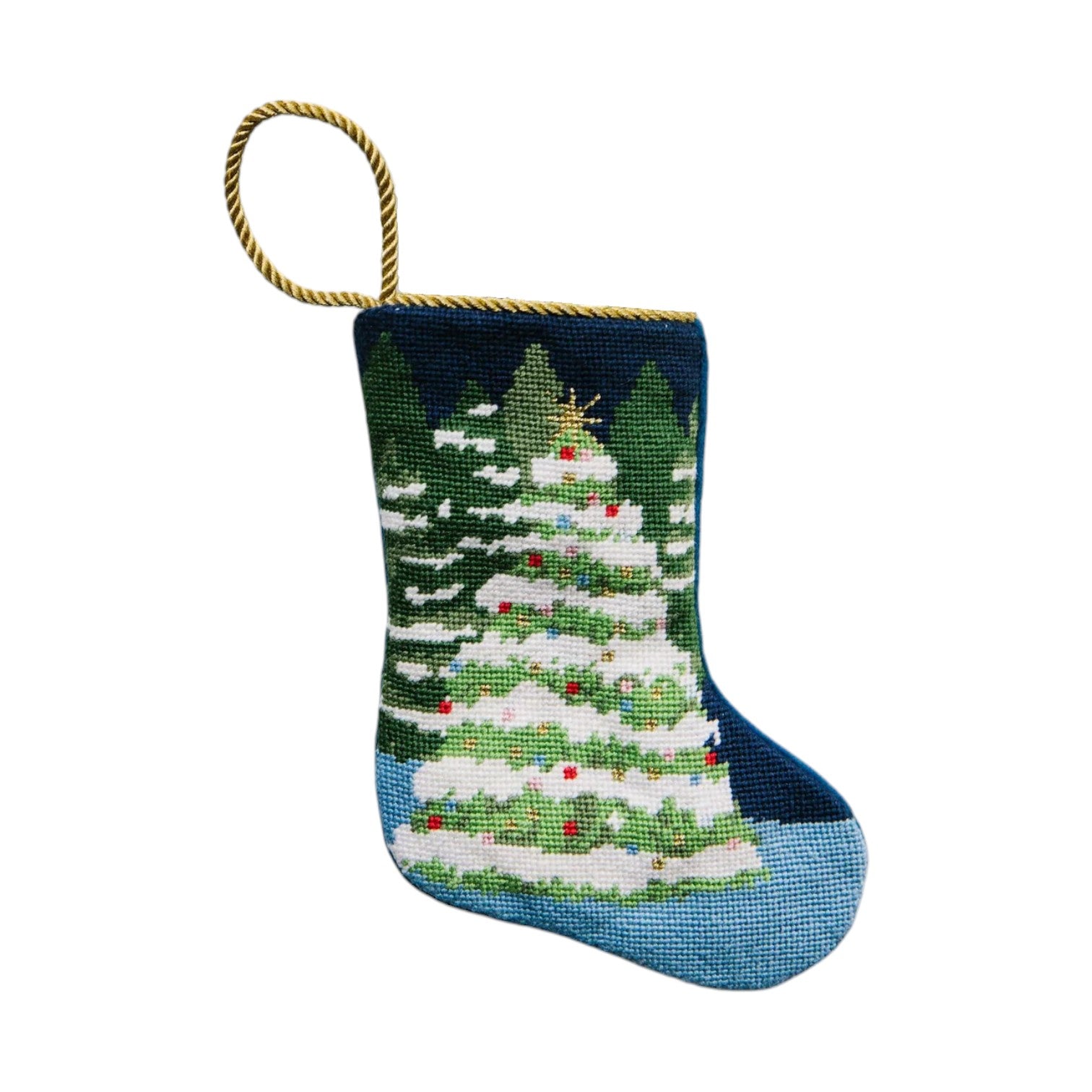 The Bauble Stockings Winter Wonderland Needle Point Stocking features a hand-stitched decorated tree with snowy trees in the background and a gold hanging loop—ideal for Christmas mantle decor.