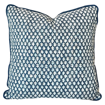 The Burma Indigo Outdoor Pillow by Associated Design features a dark blue and white geometric leaf pattern, piped edges, and premium craftsmanship—perfect for elevating any space.