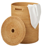 The Nema Hamper by Pigeon & Poodle features hand-woven rattan, a detachable lid leaning beside it, and a white towel draped over the edge.