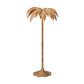 The Solana Floor Lamp by Made Goods features a woven rattan base and a large, palm-inspired leaf shade, showcased against a plain white background.