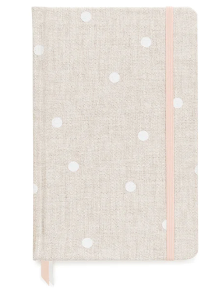 The Essential Flax Dot Journal by Sugar Paper: a beige clothbound notebook with white polka dots, pink elastic closure, and ribbon bookmark—perfect for stylish note-taking.