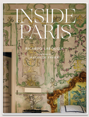 Book cover of Inside Paris by Abrams, showcasing an ornate Parisian interior with painted walls, elegant molding, and a gold-accented headboard—capturing the essence of Parisian home decor.