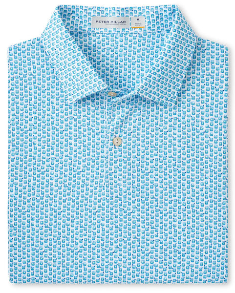 Folded blue Peter Millar Featherweight Golf on the Rocks polo with a pattern of small white figures, offering UPF 50+ sun protection, displayed against a white background.