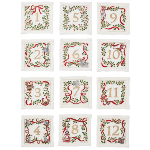 The Kim Seybert Christmas Carol Cocktail Napkins Set features twelve festive numbered squares from 1 to 12, each decorated with holiday themes and bordered by embroidered greenery and red ribbons, perfect for enhancing your holiday gatherings.