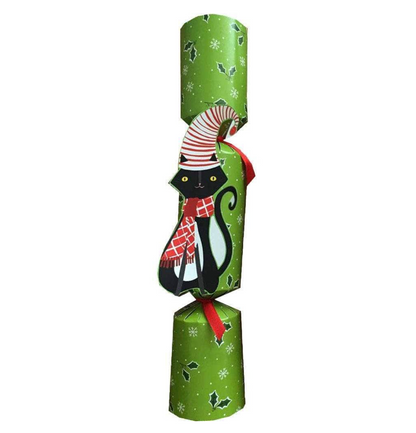 The Caspari Yule Cat Pet Christmas Cracker features green paper with white snowflakes and holly, plus a die-cut appliqué of a black cat in a red scarf and striped hat at the center.