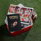 A copy of Graphic Image's "Football The Ultimate Book" sits on an open cooler beside an NFL photo book, with a football and drinks inside the cooler.