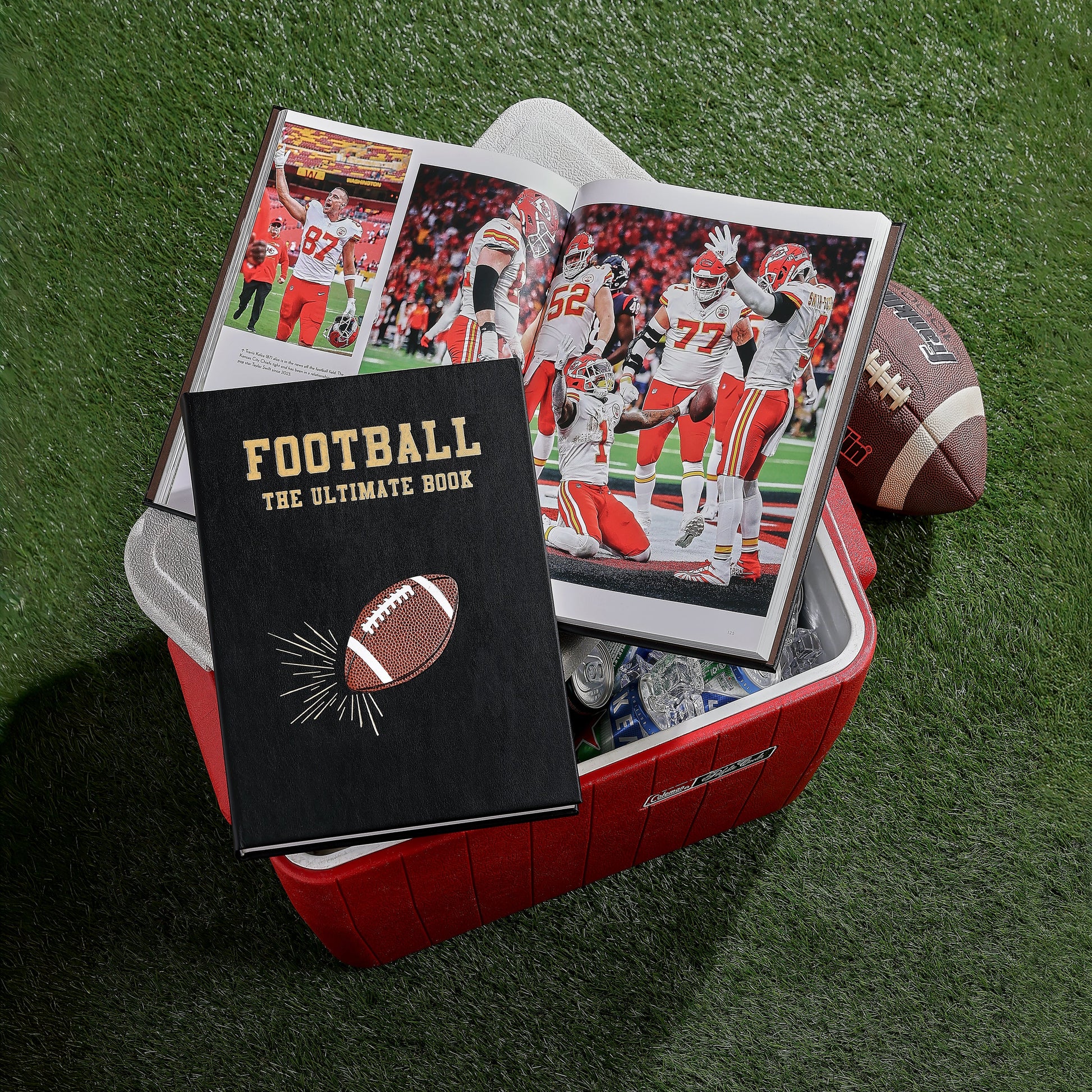 A copy of Graphic Image's "Football The Ultimate Book" sits on an open cooler beside an NFL photo book, with a football and drinks inside the cooler.