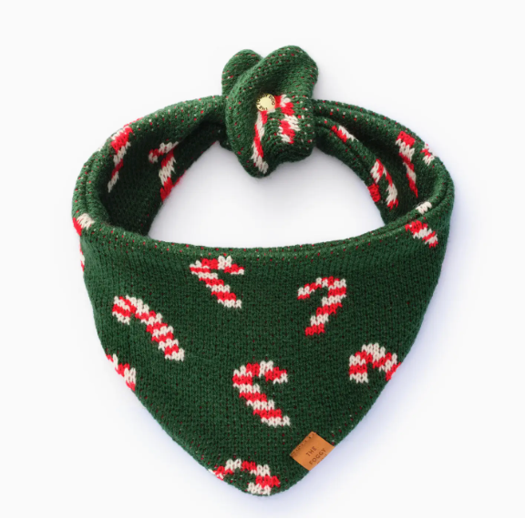 The Foggy Dog Candy Cane Knit Holiday Dog Bandana features green fabric with red and white candy cane patterns and a top knot, shown on a plain white background—perfect for festive celebrations.