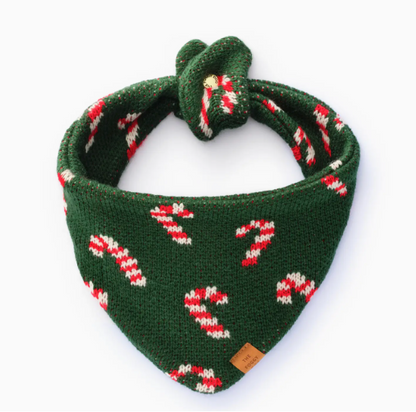 The Foggy Dog Candy Cane Knit Holiday Dog Bandana features green fabric with red and white candy cane patterns and a top knot, shown on a plain white background—perfect for festive celebrations.