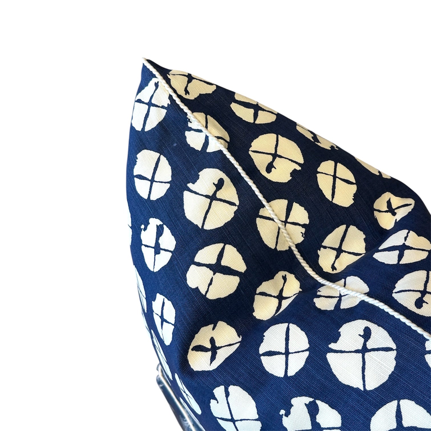 Close-up of the Obi II Reverse Pillow by Associated Design, featuring blue fabric with a white circular geometric pattern and white piping, set against a white background.