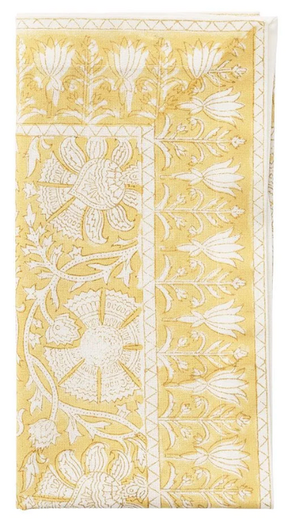 The Provence Napkin Set by Kim Seybert features folded yellow napkins with white floral and leaf embroidery—an eye-catching addition, perfect for pairing with a matching tablecloth.