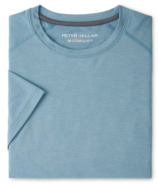 Replace sentence: Folded blue Peter Millar Aurora Performance T-shirt with antimicrobial properties and a visible brand label "Peter Millar" inside the collar, displayed on a flat surface.