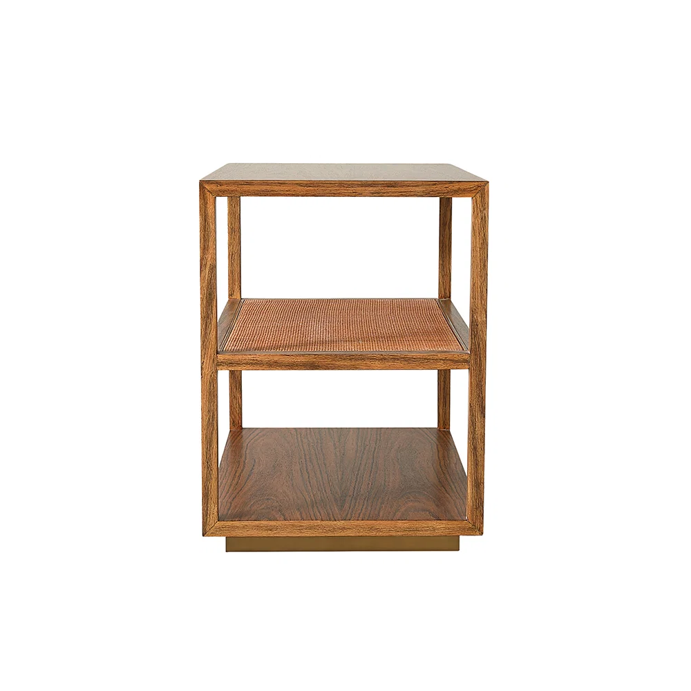 The Orca Side Table by Julian Chichester is a wooden, three-tier piece in African Walnut with an open design, featuring two antiqued rattan shelves and a solid base, shown against a white background.