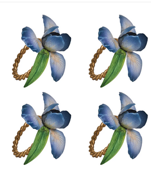 The Juliska Meadow Walk Iris Napkin Ring Set includes four identical hand-painted rings with blue and purple flowers, green leaves, and twisted gold bands—ideal for a spring tablescape.