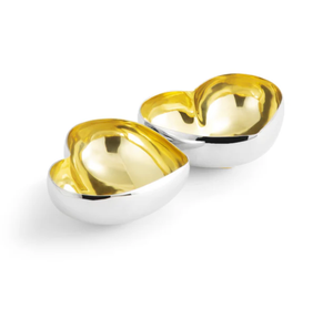 Two heart-shaped dishes from the Michael Aram Gold Heart Dish Collection feature silver exteriors with gold interiors and are placed side by side on a white background.