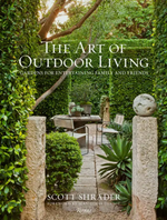 Book cover features a lush formal garden with manicured hedges, stone pillars, elegant patio furniture, and classic statues—ideal inspiration for outdoor entertaining. The text reads “The Art of Outdoor Living” by Scott Shrader, published by Rizzoli—a sophisticated coffee table book that celebrates exceptional garden design.