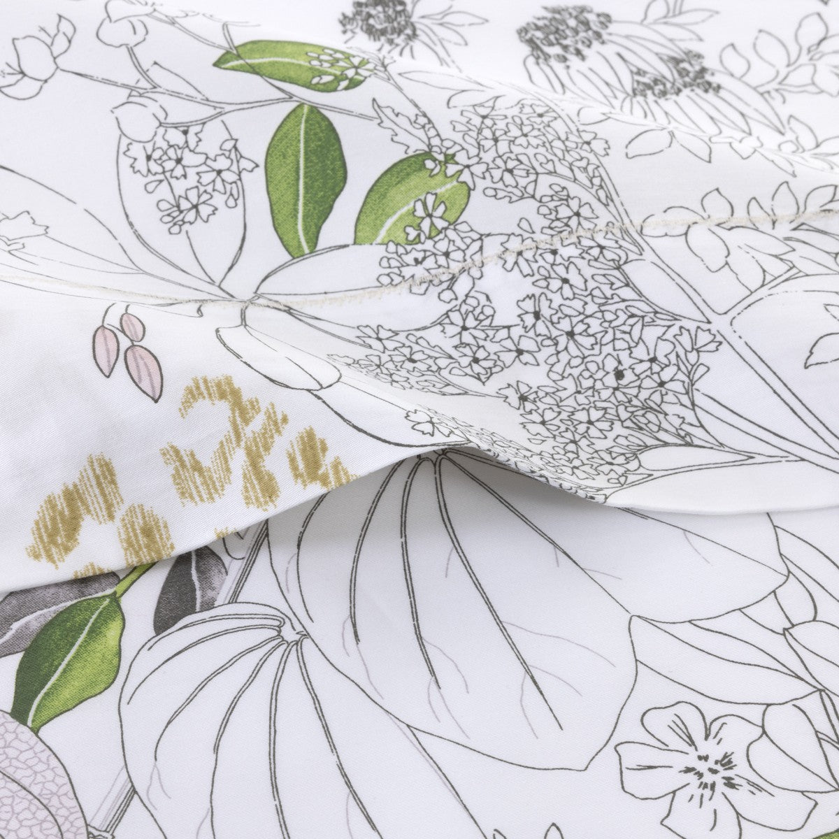 Close-up of Yves Delorme's Orchidee Bedding Collection: organic cotton sateen with a botanical pattern in green, yellow, and grey—folded for an elegant floral bedding accent.