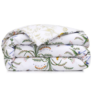 Folded white organic cotton sateen duvet cover from the Botanic Bedding Collection, featuring a colorful botanical print of green vines, orange berries, and small birds.