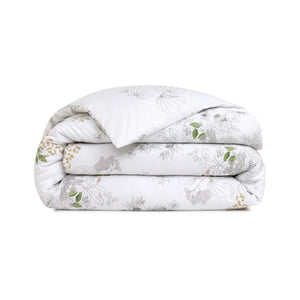 The Orchidee Bedding Collection by Yves Delorme features a folded white comforter in organic cotton sateen with green, brown, and gray botanical outlines—an elegant floral addition to your bedding.