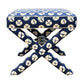 The Lee Industries X Ottoman features a square upholstered top with a blue and white circular pattern, crossed legs, and decorative edge trim—making it the perfect accent seat for any room.