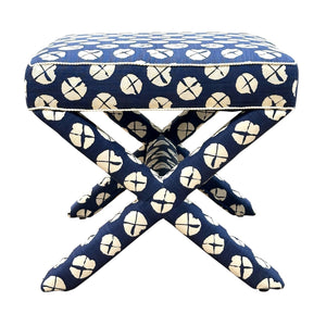 The Lee Industries X Ottoman features a square upholstered top with a blue and white circular pattern, crossed legs, and decorative edge trim—making it the perfect accent seat for any room.