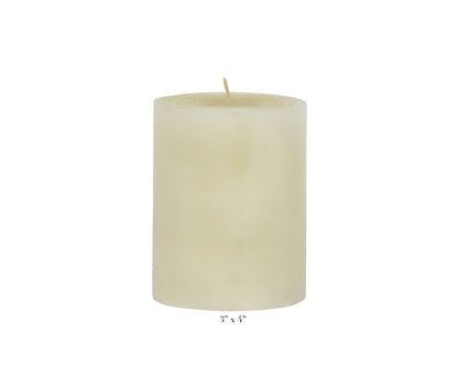 A smooth, unlit ivory candle from Perin Mowen’s Solid Pillar Candle Collection stands upright with a visible wick; its hand-rolled finish and labeled 3" x 4" dimensions emphasize timeless elegance.