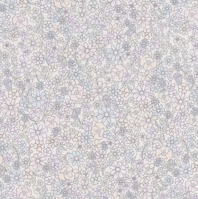 The Gooselings Enchanted Wildflowers Crib Sheet features a dense pattern of small pastel pink, blue, and purple flowers with light gray stems on white cotton sateen, adding a soft, charming touch to any nursery.