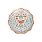The Sofia Serveware Collection by Juliska features a round ceramic plate with a romantic ruffled edge and vibrant red, blue, yellow, and green floral motifs on a white background.