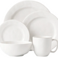 The Juliska Puro Whitewash Dinnerware Collection features two plates, a bowl, and a mug in classic white—ideal for serving teatime treats or savory tapas, elegantly displayed against a minimalist background.