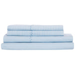 The Nandi Light Indigo Sheet Set by John Robshaw, made in India from organic cotton, features blue and white stripes and is neatly stacked against a white background.