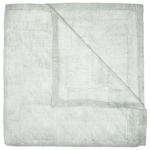 The John Robshaw Nandi Coverlet in Sage, featuring a folded design with thin dark gray vertical stripes, is partially unfolded to showcase both sides. Crafted from luxurious hand-quilted cotton voile, it adds a cozy yet stylish touch to your space.