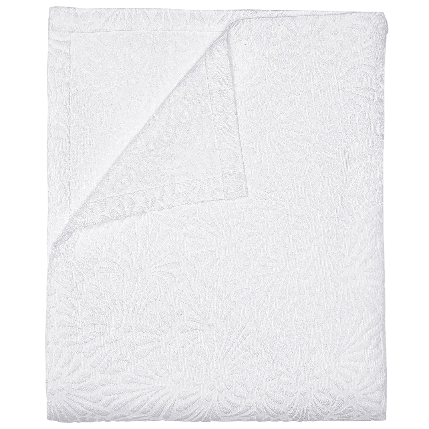 The Meera Bedding Collection by John Robshaw features a white textured bedspread with a subtle floral design, artfully shown folded with one corner turned to reveal the reverse—expertly crafted as a woven cotton coverlet that highlights exquisite Portuguese textile artistry.