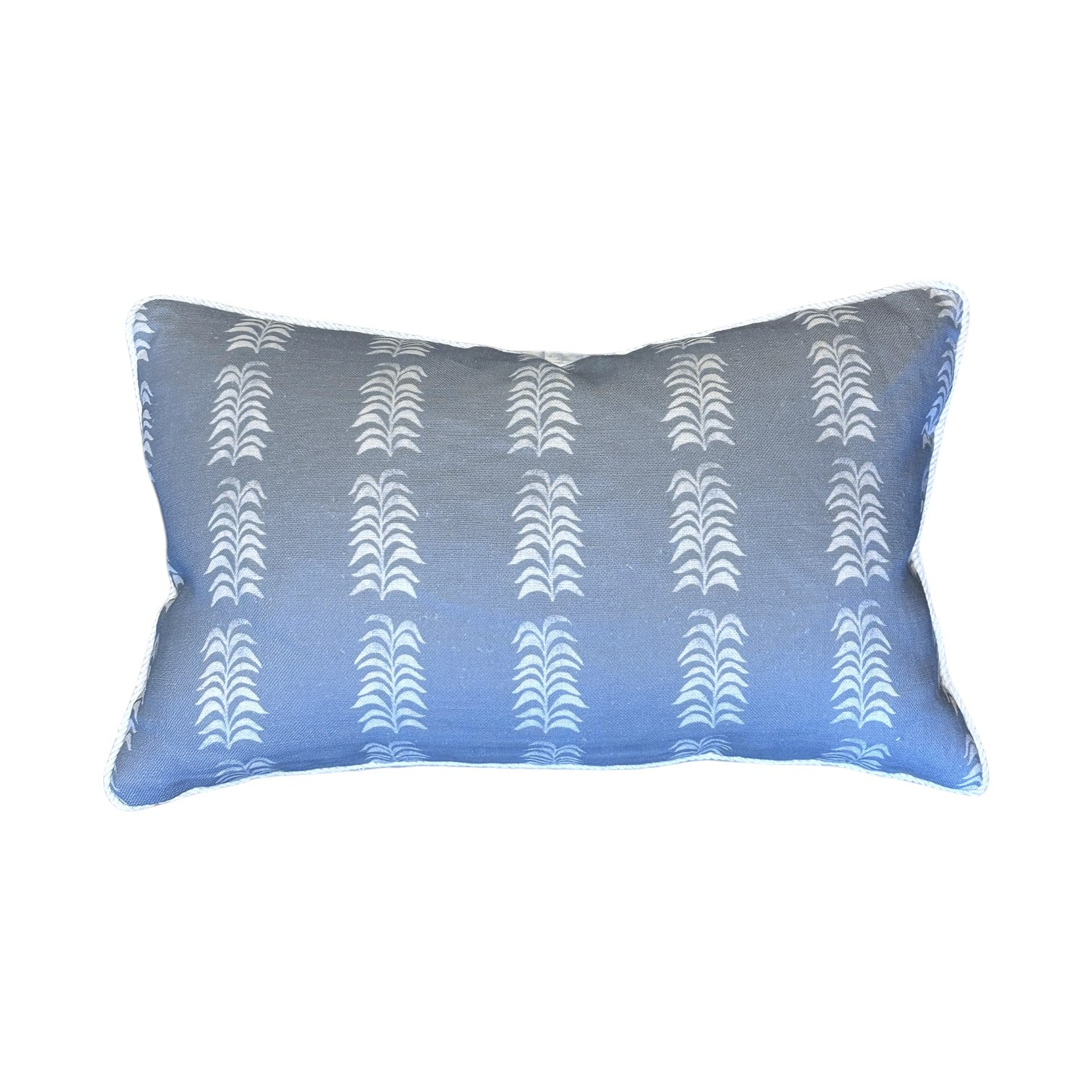The Petite Frond Blue Lumbar Pillow by Hive Custom Pillows features white vertical leaf-like patterns on a rectangular blue background, shown against a plain white backdrop.
