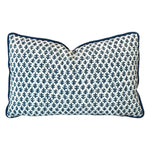 The Burma White Indigo Outdoor Lumbar Pillow by Associated Design features a navy blue leaf pattern on a white background with navy piping, adding stylish quality craftsmanship to any space.