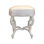 The Anastasia Bench by Hickory Chair is a white wooden stool with curved legs and a cushioned, off-white seat accented with subtle pink piping, shown against a white background.