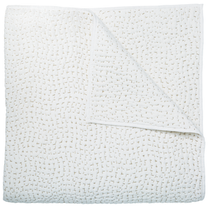 The John Robshaw Stitched Sand Coverlet is a white cotton voile quilt featuring a subtle stitched pattern, crafted in India and shown neatly folded with one corner turned down to reveal the reverse.