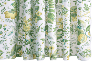 The Matouk Pomegranate Shower Curtain, Citrus displays green leaves and yellow flowers on a crisp white backdrop.