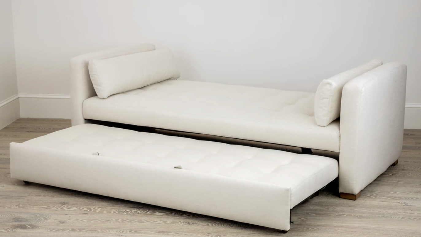 A Day Bed in Laguna Cloud Crypton by Lee Industries, featuring a pull-out trundle, elegantly complements the room's dimensions as it rests on a light wood floor.