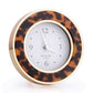 The Addison Ross Round Silver Alarm Clock features a white face with black numbers and silver hands, set in an elegant gold and tortoiseshell enamel frame—a stylish addition to any bedside table.
