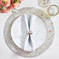 A white plate with a marble pattern sits on the Camellia Gray Placemat by Kim Seybert, topped with a folded gray napkin in a silver ring. Two glasses and a floral arrangement are placed nearby.