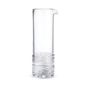 The Simon Pearce Echo Lake Cocktail Carafe, a tall clear glass vessel with a narrow spout and textured base, stands against a plain white background, perfect for serving refreshing cocktails or classic martinis.
